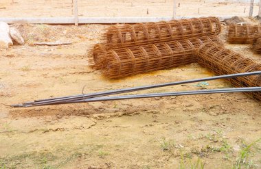 İnşaat alanında yerde çelik çubuk rulo.