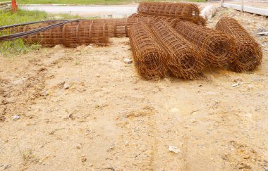 İnşaat alanında yerde çelik çubuk rulo.