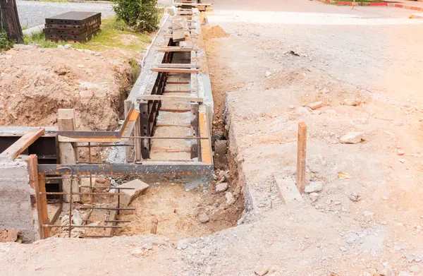yoldaki inşaat alanındaki beton kanalizasyon oluğu