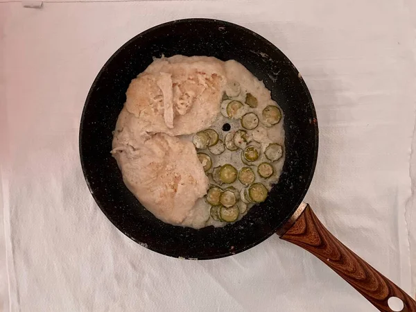 Tavada kızarmış hindistan cevizi sütlü tavuk ve dilimlenmiş kabak.