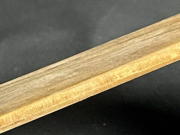 Obliquely lit wooden base slide on a black background