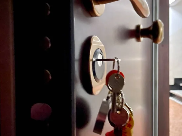 Bunch of keys in the lock of the security door of an apartment building