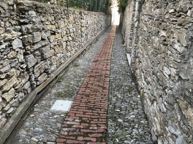 Narrow cobblestone path between two stone walls