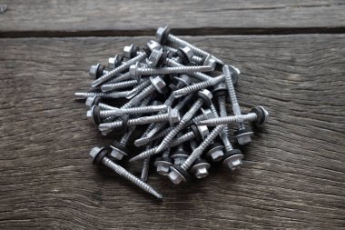 Ahşap arka planda gri vida.