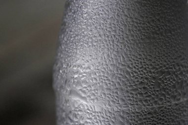 Siyah ve beyaz ton. Ahşap masada plastik içme suyu şişesi.