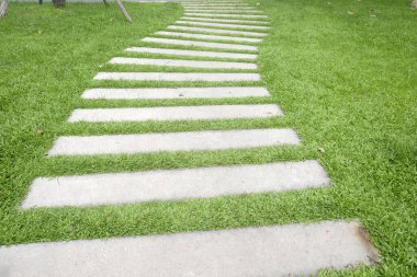 Gri renkli basamaklar, çıplak çizgi beton kaldırımlar ve bahçedeki yeşil çimen halı çimenleri.