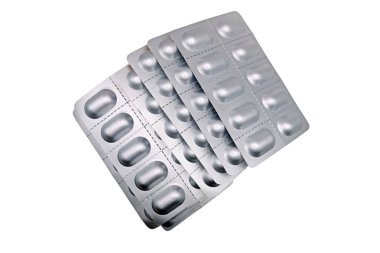 Beyaz arka planda izole edilmiş kapsül haplarından oluşan gümüş alüminyum su toplayıcı paketler. Kesme yolu ile. İlaç imalatı için konsept ambalaj. Eczane
