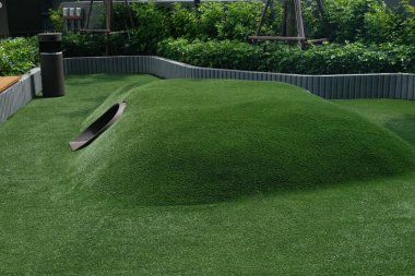 Suni Çimen Tepeleri ve Tüneli olan Açık Hava Oyun Alanı