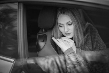 Sanat eserleri. Güzel, şık bir kızın arabada otururken çekilmiş siyah beyaz bir fotoğrafı. Arabanın camlarında güzel yansımalar var..