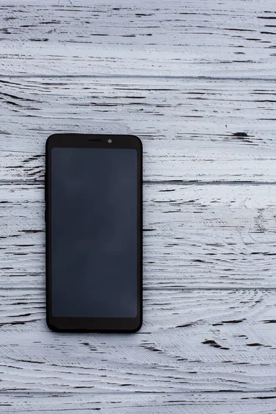 Görüntü Olmayan Siyah Bir Cep Telefonu Açık Ahşap Desenli Bir — Stok fotoğraf