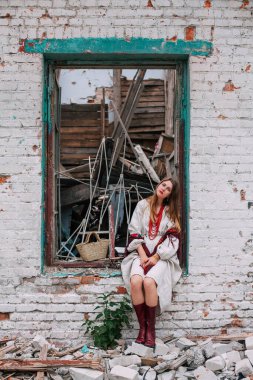 Ukrayna 'daki savaşın teması üzerine sanat çalışmaları. Ukraynalı hayal kırıklığına uğramış bir kadın, Rus ordusu tarafından bombalanan binanın penceresinde oturuyor..