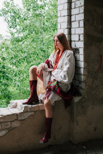 Ukrayna 'daki savaşın teması üzerine sanat çalışmaları. Ukraynalı hayal kırıklığına uğramış bir kadın, Rus ordusu tarafından bombalanan binanın penceresinde oturuyor..