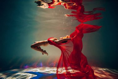 Sanat eserleri. İnce, bronz tenli, atletik vücutlu, sarı saçlı, kırmızı kumaşlı, açık renk iç çamaşırlı, havuzda dalıp dönen bir kız. Tasarım ve dekorasyonunuz için estetik resim.