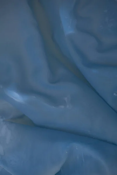 Kreatives Bild Eines Nassen Hellblauen Faltigen Stoffes Auf Dem Wasser — Stockfoto