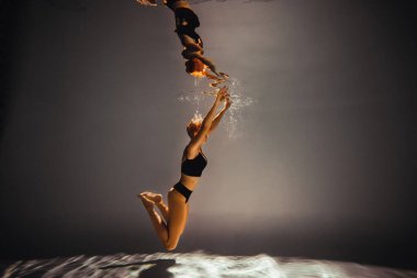 Sanat eserleri. Zayıf, bronz tenli, atletik vücutlu, sarı saçlı, siyah iç çamaşırlı bir kız havuza dalıyor. Tasarım ve dekorasyonunuz için estetik resim.