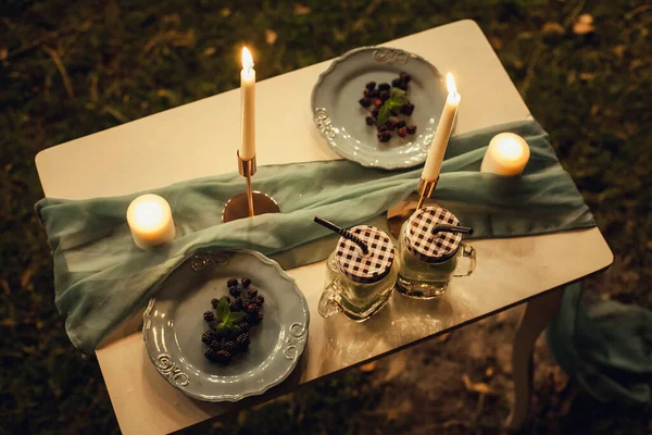 桑盘和杯子站在一个节庆的 装饰的桌子上 晚上用一块布装饰 为您的创意设计和插图的图像 — 图库照片
