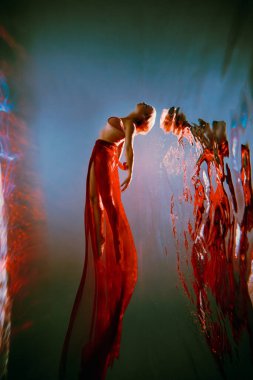 Sanat eserleri. İnce, bronz tenli, atletik vücutlu, sarı saçlı, kırmızı kumaşlı, açık renk iç çamaşırlı, havuzda bale pozu veren bir kız. Tasarım ve dekorasyonunuz için estetik resim.