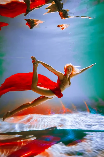 艺术品 一个身材苗条的晒黑了头发的女孩 身材苗条 金发碧眼 穿着红色的料子和浅色的内裤 在游泳池里跳芭蕾舞 设计或装饰时的美感形象 — 图库照片