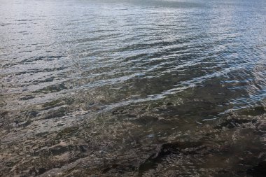 Nehirdeki suyun arkaplan görüntüsü, küçük dalgalarla, tasarımınız ya da doğa ya da seyahat hakkındaki diğer dekorasyonlar için.