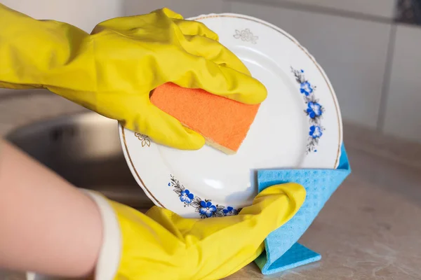 一个女孩在厨房里用抹布和海绵洗盘子 情节涉及家务活 清洁和日常活动 厨房配上轻质瓷砖和质感强的工作台 — 图库照片
