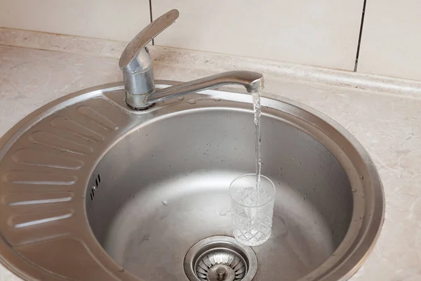 食器洗いの構成 水道水のジェットが洗面台の透明なガラスに注ぐ キッチンケア 清潔感に関するイメージ — ストック写真