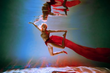 Sanat eserleri. İnce, bronz tenli, atletik vücutlu, sarı saçlı, kırmızı kumaşlı, açık renk iç çamaşırlı, havuzda bale pozu veren bir kız. Tasarım ve dekorasyonunuz için estetik resim.