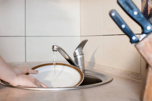 若い女の子が台所で食器を洗っている プロットは家事 清潔さと毎日の活動についてです ライト家具 テクスチャカウンターとキッチン用品 — ストック写真