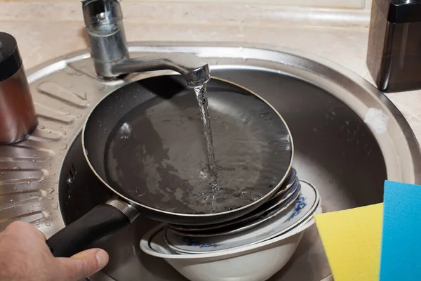 フライパン 水道水の下で流しの中の色のついたぼろ類を台所で洗う 清潔感のイメージ — ストック写真