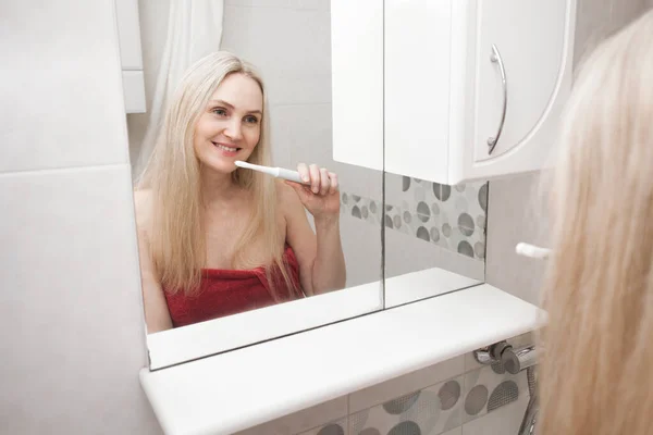 Lachende Sexy Blonde Vrouw Een Rode Handdoek Poetst Haar Tanden — Stockfoto