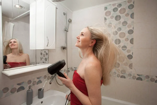 Sorrindo Mulher Loira Sexy Seca Cabelo Com Secador Cabelo Banheiro — Fotografia de Stock
