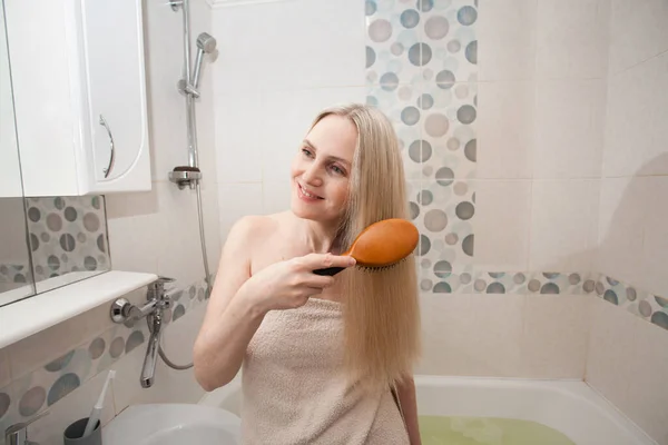 Een Blonde Vrouw Een Witte Handdoek Kamt Haar Lange Blonde — Stockfoto