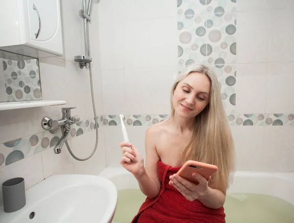 Uma Menina Loira Sorridente Uma Toalha Vermelha Com Uma Escova — Fotografia de Stock