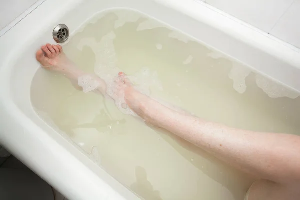 Λεπτά Γυναικεία Πόδια Βρίσκονται Κάτω Από Νερό Μια Μπανιέρα Σαπουνόφουσκες — Φωτογραφία Αρχείου