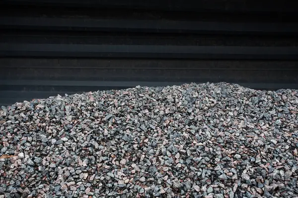 Stock image A hill of large gravel against the background of a metal profile. An image for your design or creative illustrations about construction and roads.