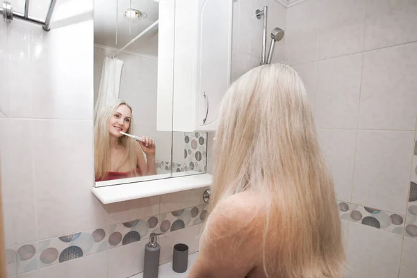 Lachende Sexy Blonde Vrouw Een Rode Handdoek Poetst Haar Tanden — Stockfoto