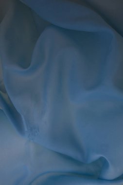Creative image of a wet light blue wrinkled fabric on the water, with beautiful highlights, for your stylish design or illustrations.