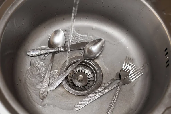 食器洗いの構成 水道水のジェットがフォークやスプーンで洗面台に注ぐ キッチンケア 清潔感に関するイメージ — ストック写真