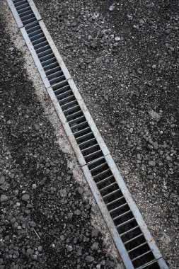 Kanalizasyon için demir kanalizasyon şebekesi asfaltlanmış bir yolda moloz, siyah ve beyaz desenli bir fotoğraf. Yaratıcı tasarımın veya çizimlerin için arkaplan resmi.