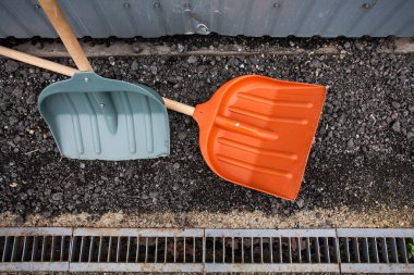 Metal karavanın yakınındaki çakıllarda iki büyük kürek çalışmaya başlamak için bekliyor. Çalışma ve inşaat hakkındaki yaratıcı tasarımınız için bir resim.