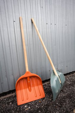 Metal karavanın yakınındaki çakıllarda iki büyük kürek çalışmaya başlamak için bekliyor. Çalışma ve inşaat hakkındaki yaratıcı tasarımınız için bir resim.