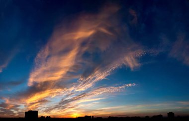 Turuncu pembe menekşe bulutların muhteşem görkemli görüntüsü mavi akşam gökyüzü. Detaylı çoklu katmanlar atmosferin düşük yüksek katmanlarıyla oynar. Ölen gün, yakıcı sıcak günbatımı. Panoramik, pankart için çok katmanlı bir dekorasyon. Kumsalda dinlenirken.