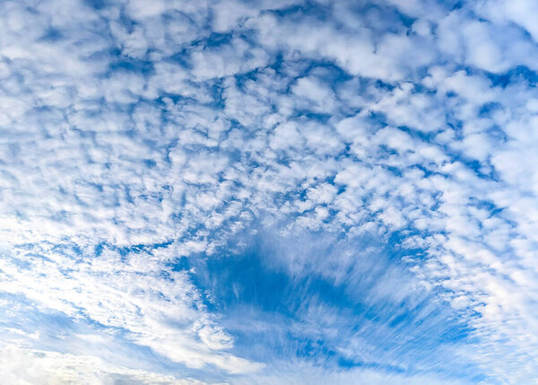 Вентилятор перистых облаков разворачивается на голубом небе. Панорамный вид на широкоугольный пейзаж. Всеобъемлющее впечатление бесконечных возможностей, свободы и полета.