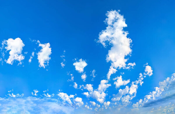 Фанат кучевых облаков разворачивается на голубом небе. Панорамный вид на широкоугольный пейзаж. Всеобъемлющее впечатление бесконечных возможностей, свободы и полета.