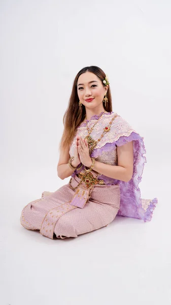 一个穿着传统泰式服装的美丽的泰国女孩奢华的泰国身份文化 摆出一副因孤独的白人背景而微笑的样子向她致敬 — 图库照片