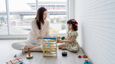 Anne ve kızı evde eğitici ahşap oyuncaklarla oynayarak vakit geçiriyorlar, eğlenceli ev aktiviteleriyle bağ kurup öğreniyorlar..