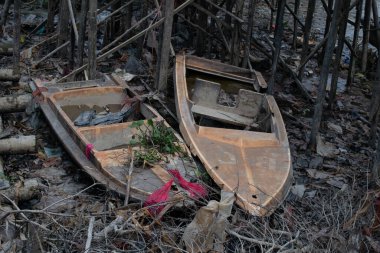 Hasarlı ve artık kullanılmayan eski bir sürat teknesi suyun çekildiği nehrin kıyısında yatıyordu.