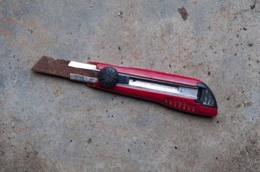 Gri soyut desenli çimento arka planda kater bıçağı.