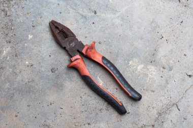 Eski paslı kerpeten tel kesme aracı gri soyut desenli çimento arka plan.