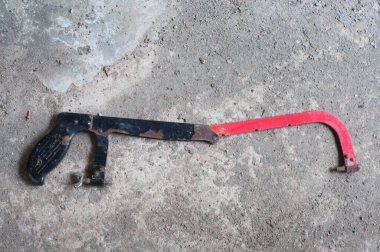 Gri desenli çimento arka planında kırık demir testeresi.