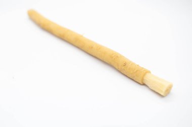 Beyaz arka planda eski geleneksel İslami doğal diş fırçası miswak ya da siwak